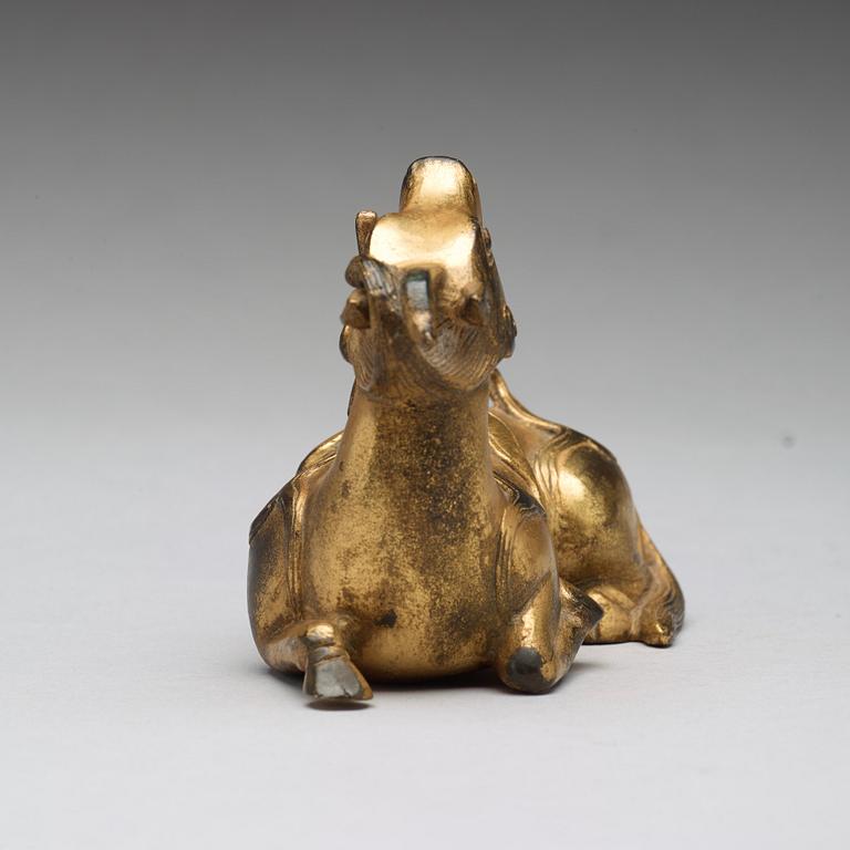 A gilt bronze figure of a reclining mythical animal, Qing dynasty, 19th Century.