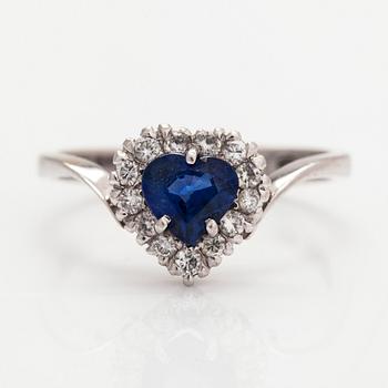 An 18K white gold ring, with a heart-shaped sapphire and diamonds totalling approximately 0.15 ct.