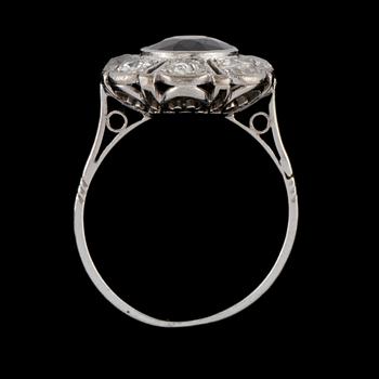 RING, platina med äldre briljantslipade diamanter samt ovalslipad blå safir, 1900-talets början. Vikt.