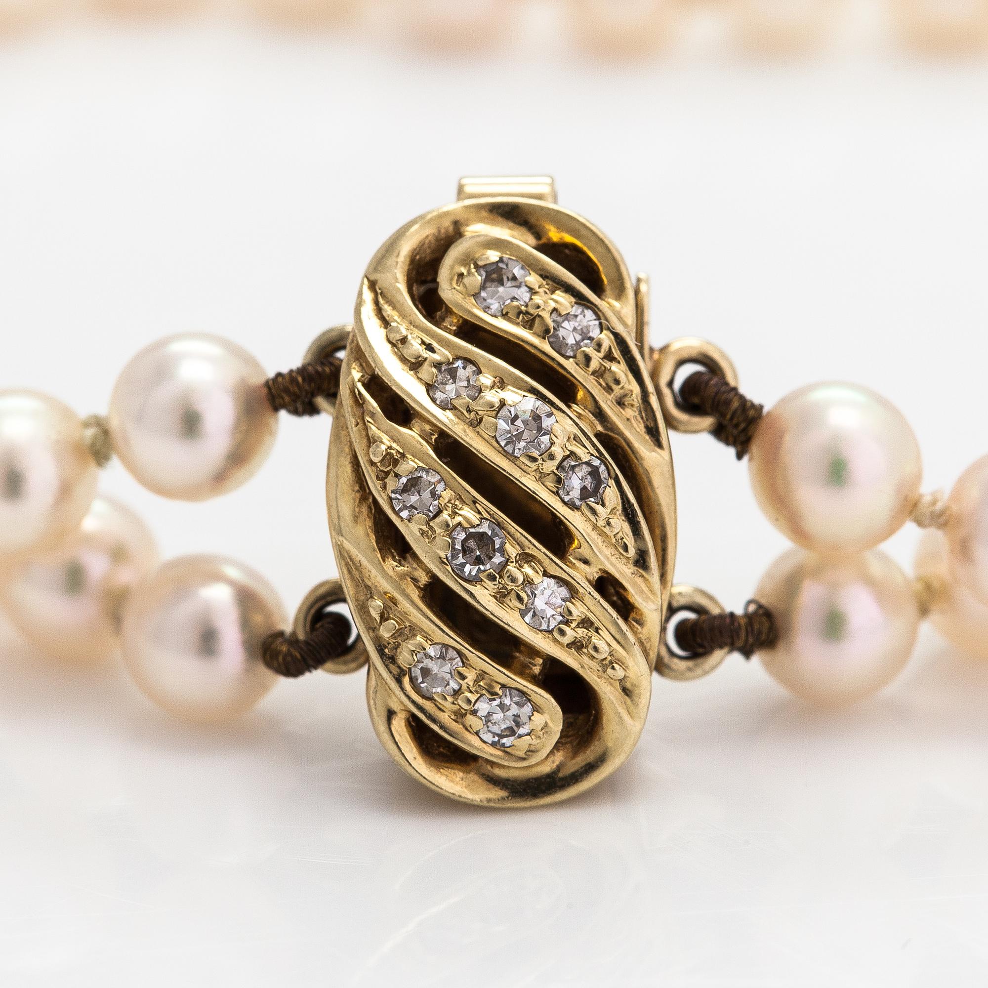 A 2-strand pearl bracelet with cultured pearls, lock 14K gold and diamonds, ca 0.13 ct in total.