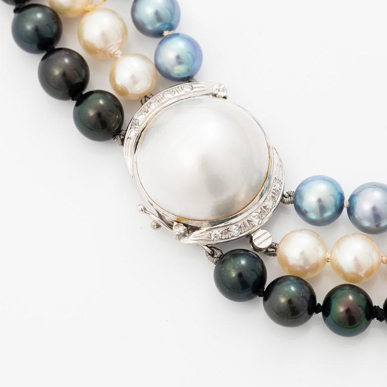 Three-row pearl necklace with cultured pearls, with an 18K white gold clasp set with a mabé pearl and octagonal-cut diamonds.