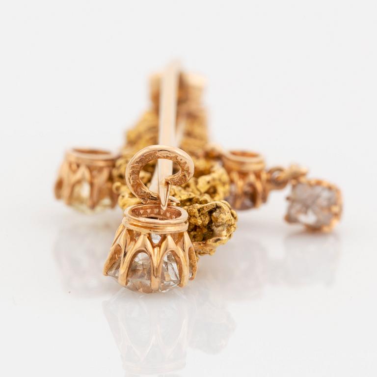 A gold brooch set with old-cut diamonds and an uncut diamond.