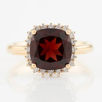 Ring in 18K gold with a faceted garnet and round brilliant-cut diamonds.