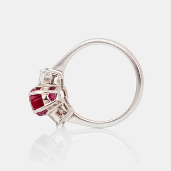 A 3.164 ct Burmese untreated 'Pigeon Blood-red' ruby, flanked by two step-cut diamonds.