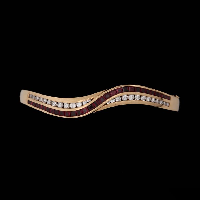 A bangle with carré cut rubies and brilliant cut diamonds, app. 1.10 ct.