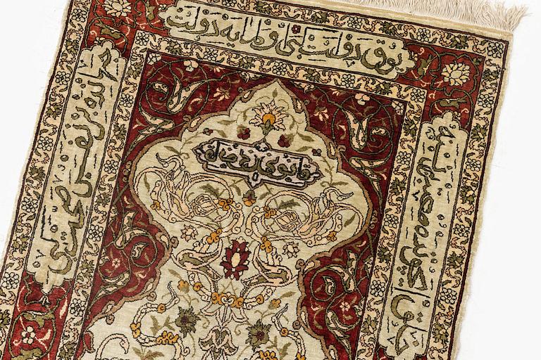 A silk and metal Hereke rug, c. 80 x 51 cm.