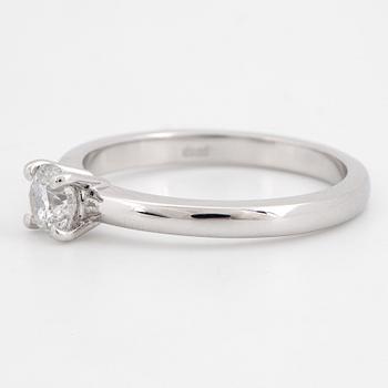 An 18K white gold ring set with a round brilliant-cut diamond.