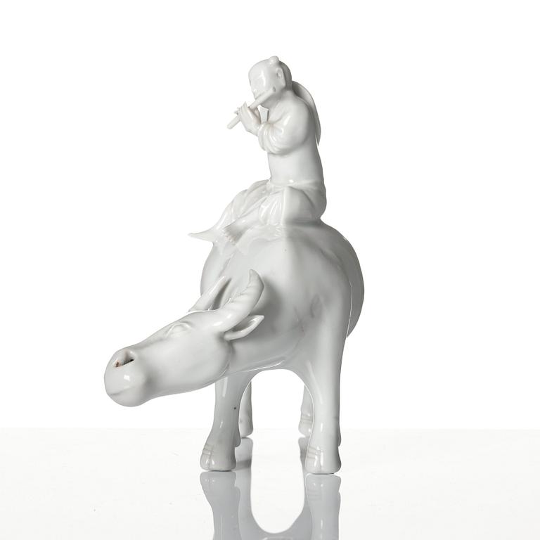 A blanc de chine figure of a boy on an ox, late Qing dynasty.