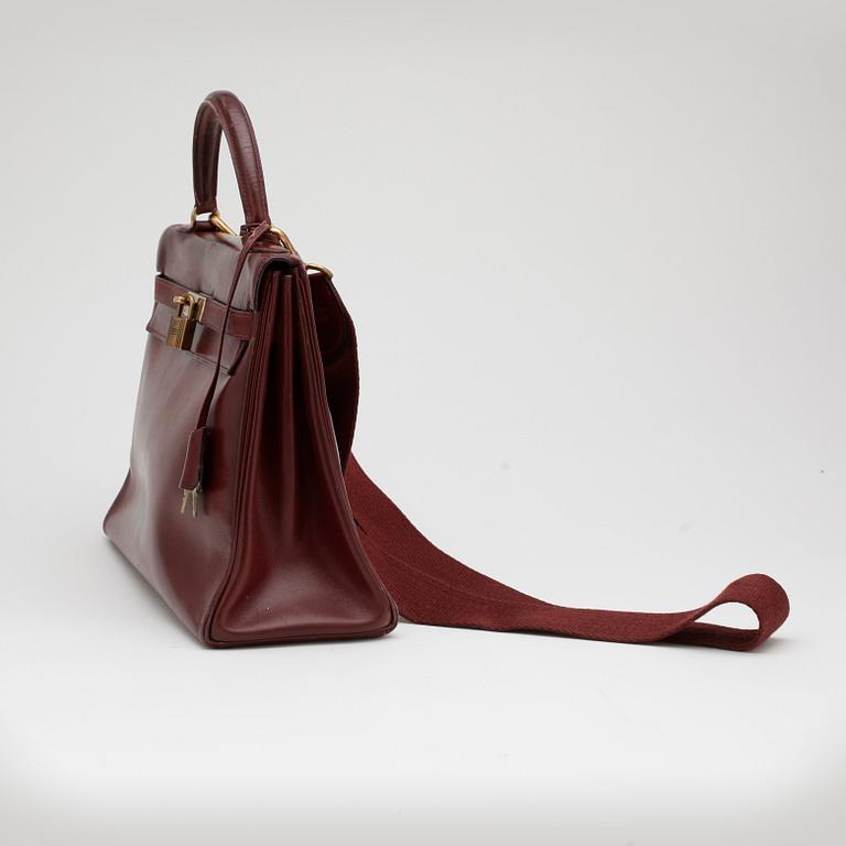 HERMÈS, a burgundy read leather "Kelly 32" bag, 1960's.
