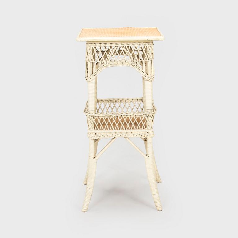 A mid-20th-century three-piece rattan furniture set including two armchairs, and a table.