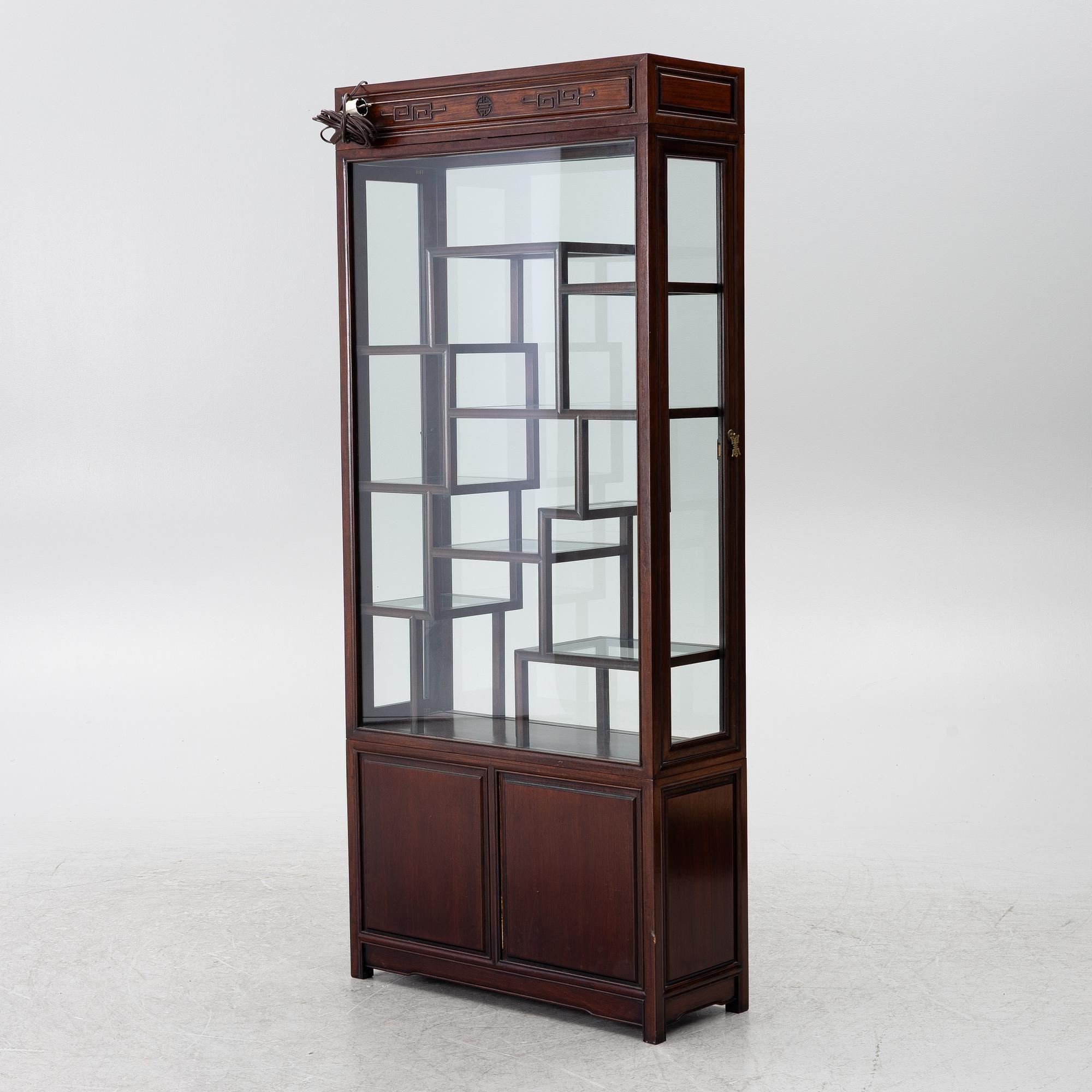 A Chinese display cabinet, wood and glass, later part of the 20th century.