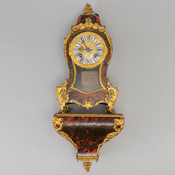 A Louis XV-style mantle clock with console base.