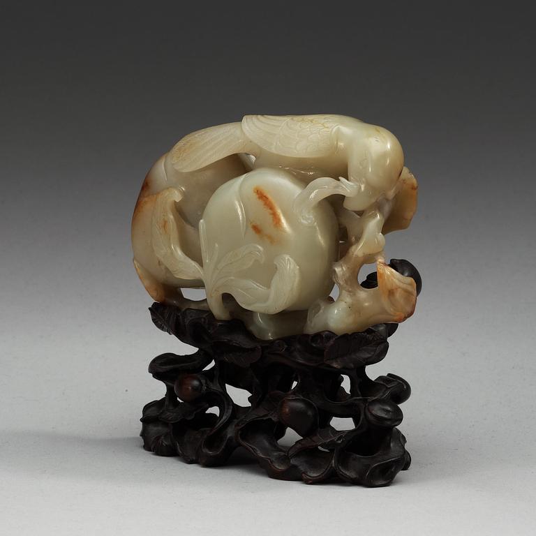 A carved nephrite figure of a parrot among peaches, Qing dynasty.