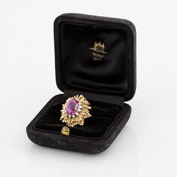 A Sterlé ring in 18K gold and platinum set with a pink faceted sapphire and round brilliant-cut diamonds.