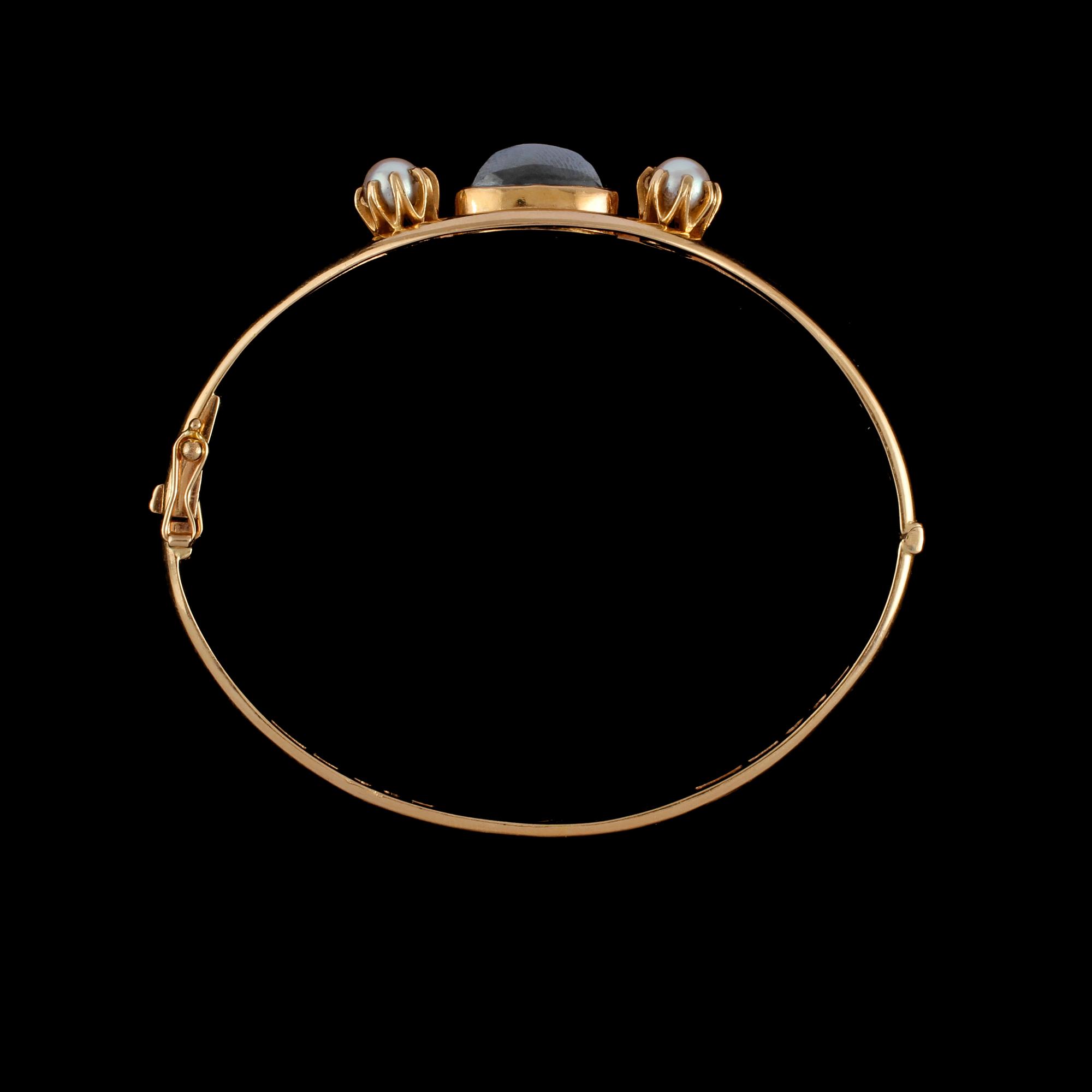 ARMRING, 18K guld med 2 odlade pärlor samt cabochonslipad hematit. Vikt 22,3 g.