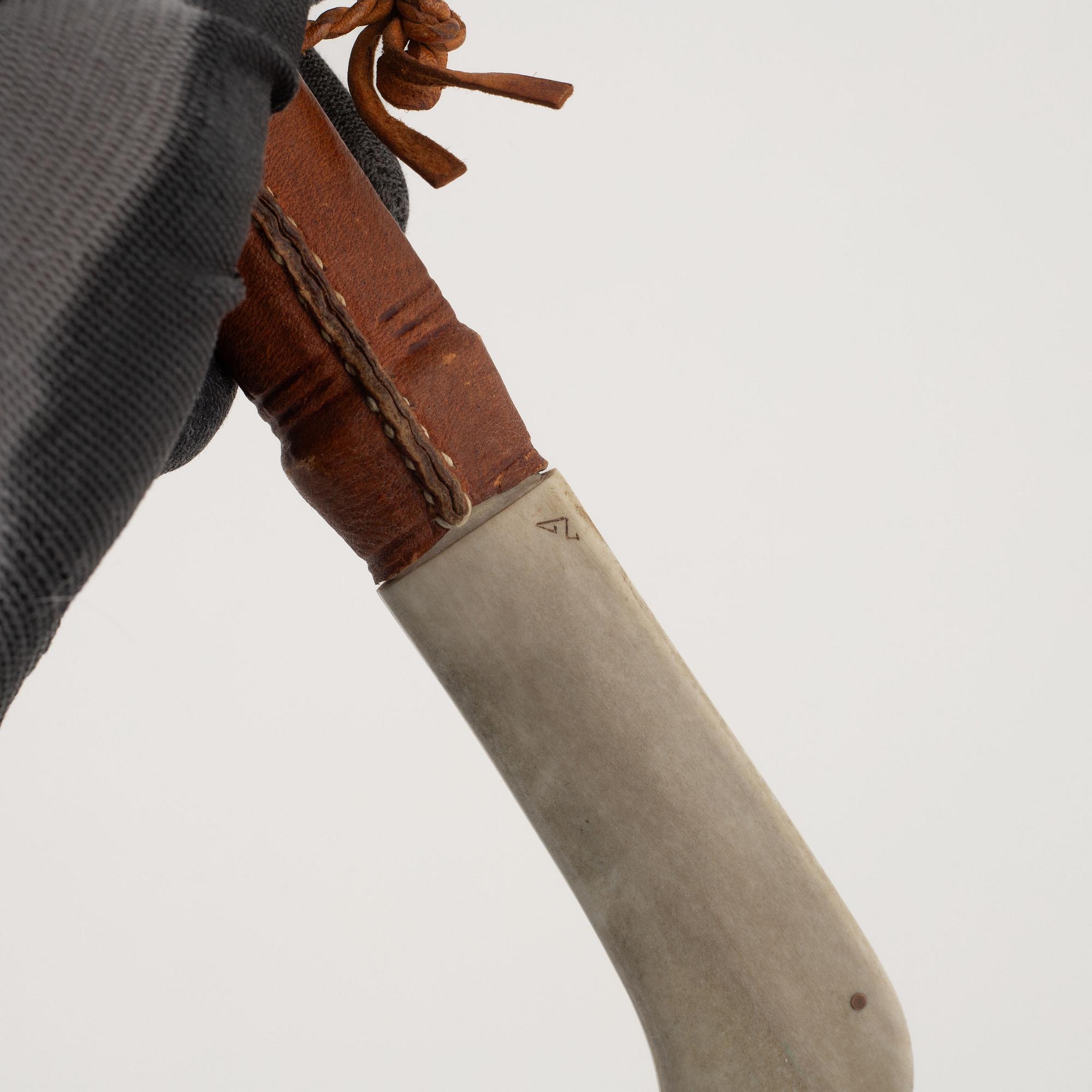 A reindeer horn knife, signed.