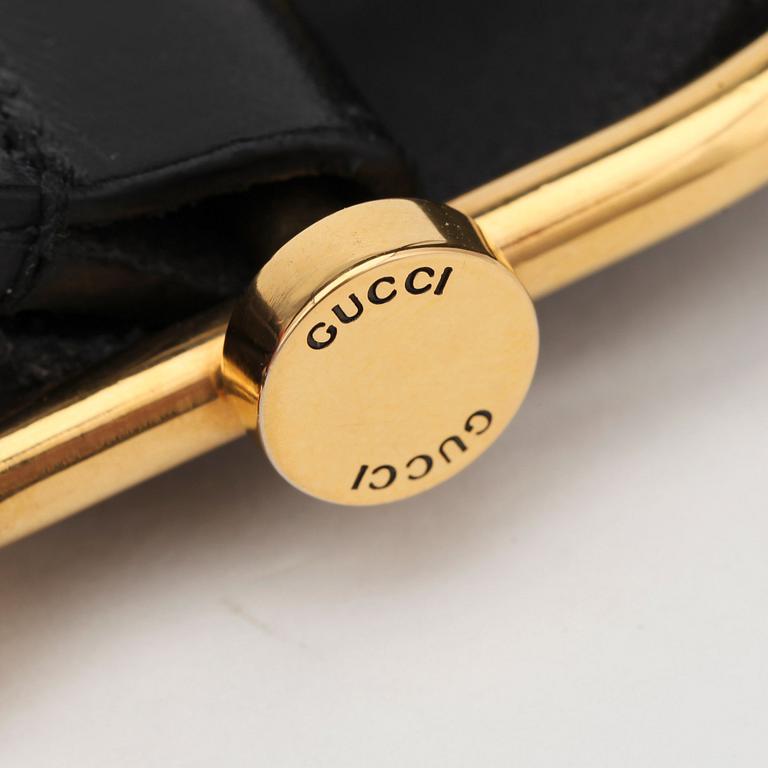 GUCCI, a black leather belt.