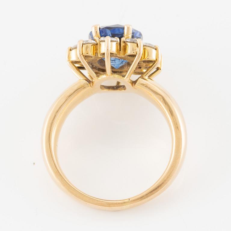 Ring 18K guld med en fasettslipad safir och runda briljantslipade diamanter.