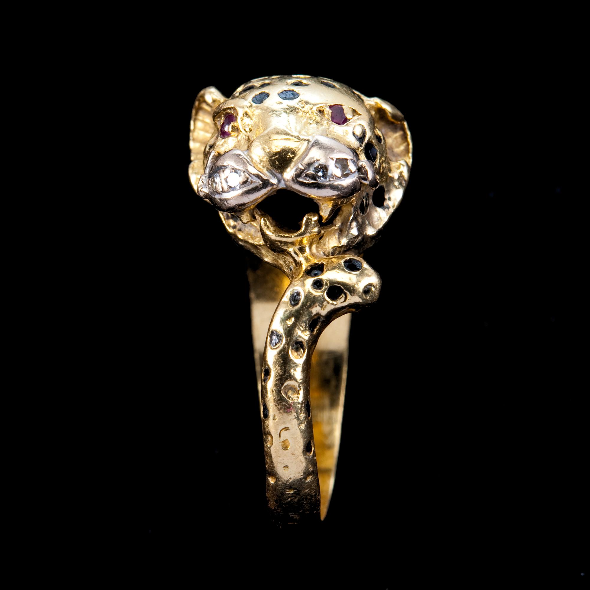 A RING shaped like a leopard with enamel, rubies and brilliant cut diamonds.