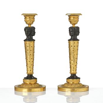 A pair of Napoleon III gilt and patinated bronze candlesticks, later part 19th century.