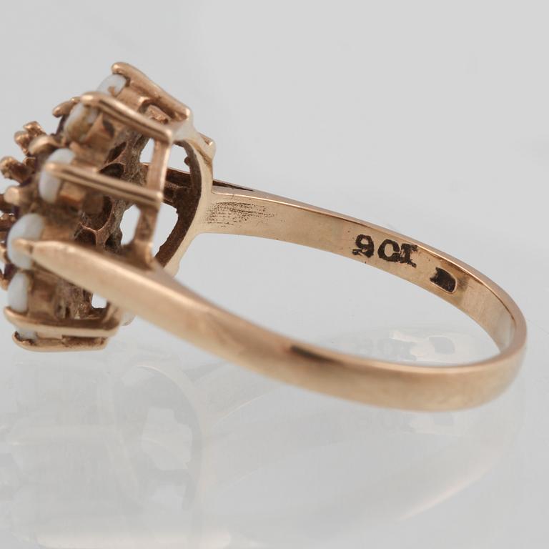 RING, 8K guld med 10 vita opaler samt 10 syntetiska rubiner, troligtvis Sheffield, 1800-talets slut. Vikt 3,4 g.