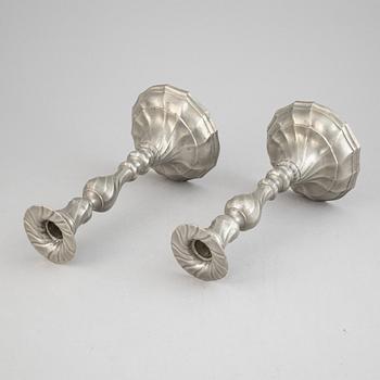 A pair of rococo style pewter candlesticks, 19th Century.
