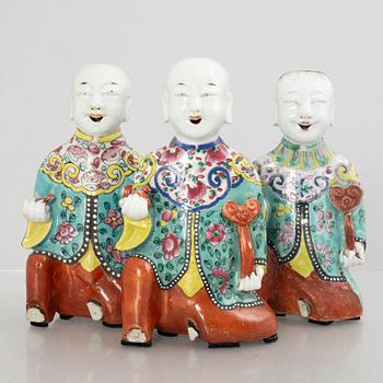 A group of three Chinese porcelain 'Laughing boys' figures, Qing dynasty and later.