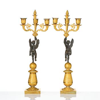 A pair of Empire three light ormolu and patinated bronze candelabra.