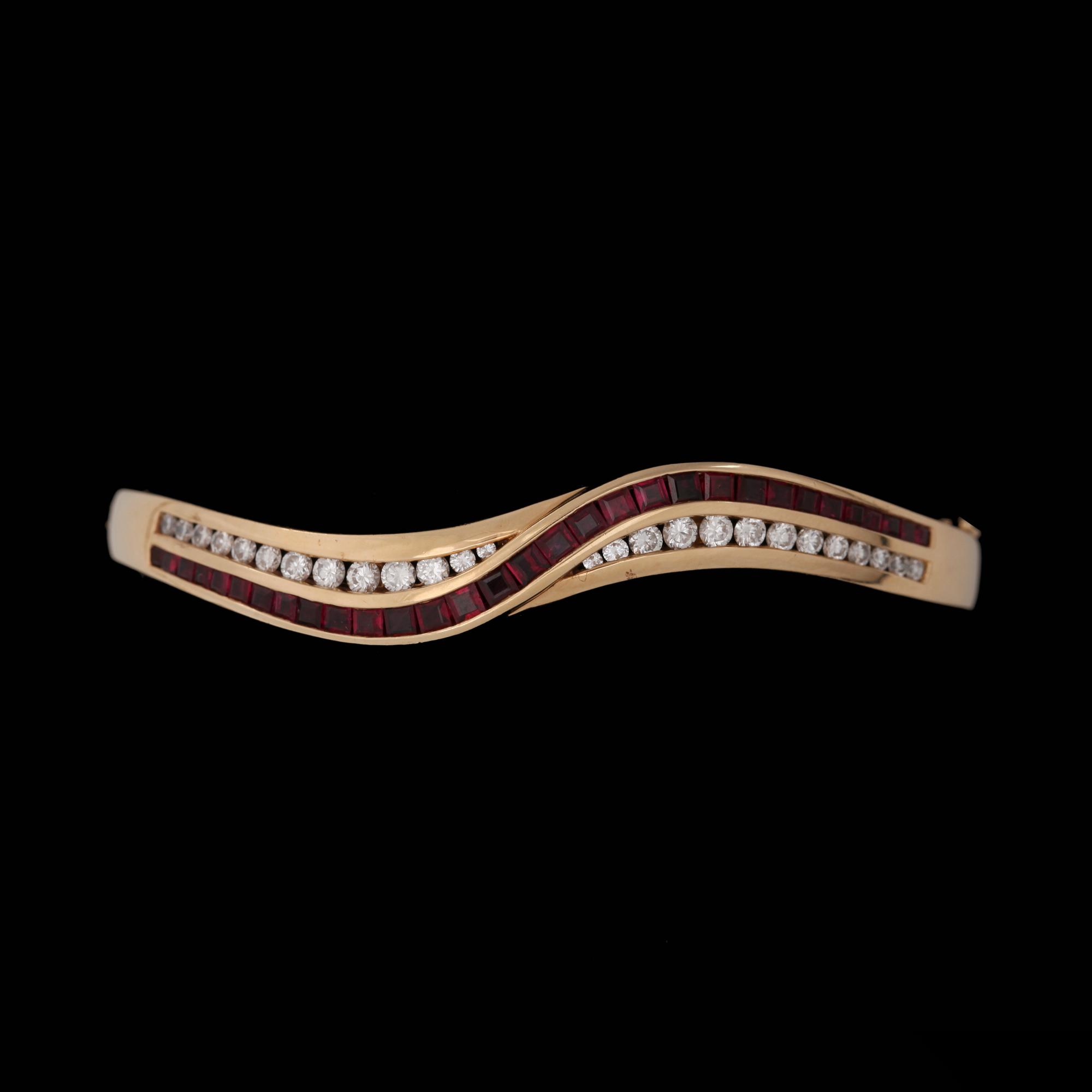 A bangle with carré cut rubies and brilliant cut diamonds, app. 1.10 ct.