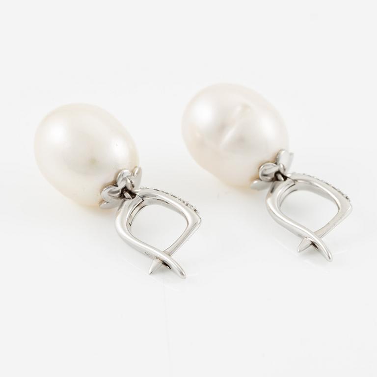 A pair of 14K gold earrings with cultured freshwater pearls and round brilliant-cut diamonds.