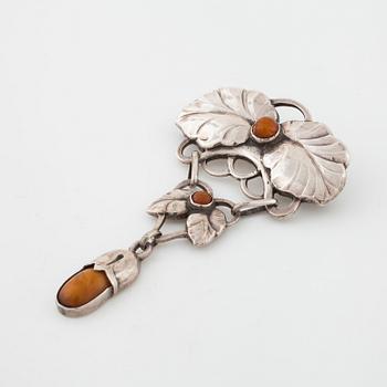 ADAM BENTZEN GRAESER, Copenhagen, a cabochon cut amber brooch.