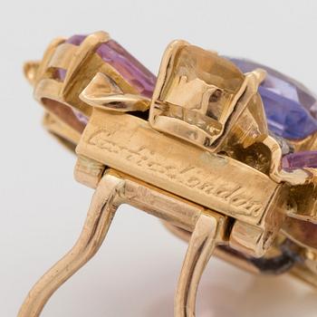 A pair of multi coloured sapphire and brilliant cut diamond clip brooches, one signed Cartier London.