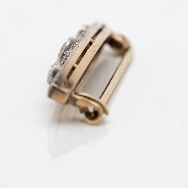 A 14K gold and platinum brooch with diamonds.