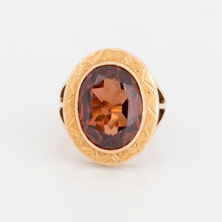 A ring with a faceted brown stone.