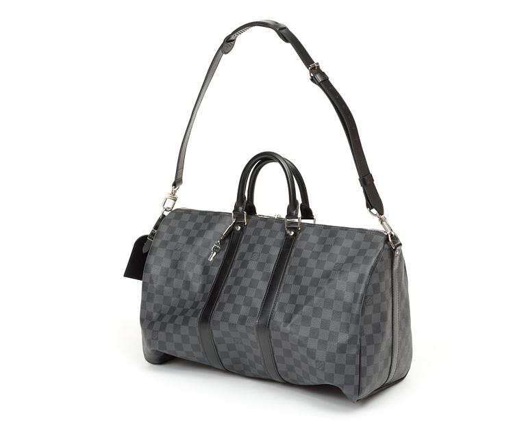 A black damier ebene canvas weekend bag by Louis Vuitton.
