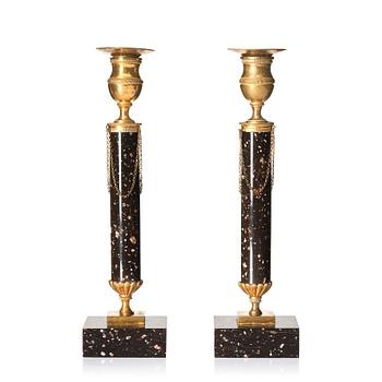A pair of late Gustavian porphyry and gilt brass candlesticks, circa 1800.