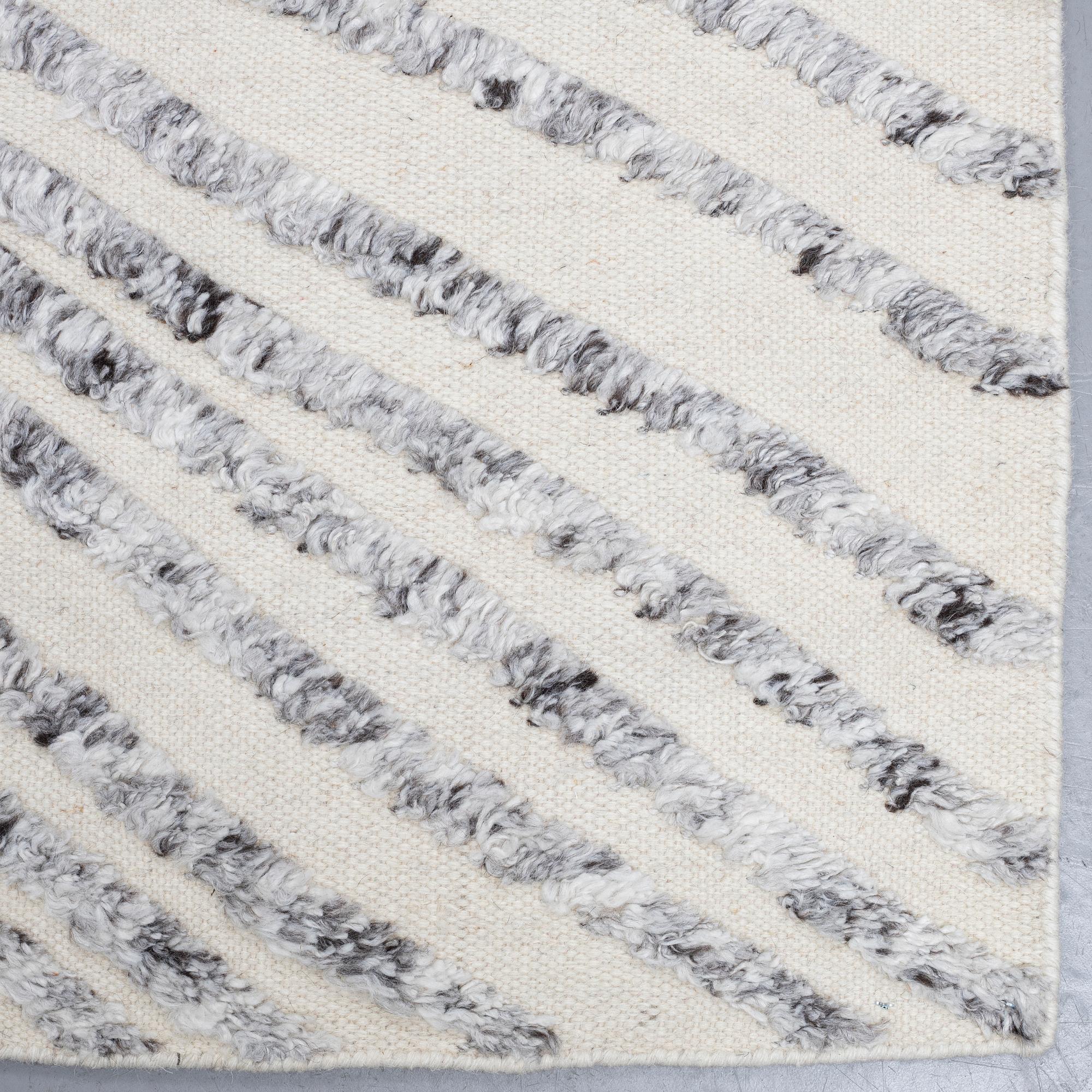 A CARPET, flat weave, with knoted detalis in relief, ca 300 x 240 cm.