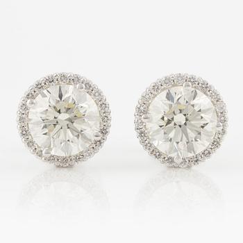 A pair of 18K gold earrings with round brilliant-cut diamonds.