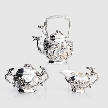 1162. A three piece japanse silver 'dragon' tea set, Signed 三代目 大島, third generation Oshima, early 20th Century.