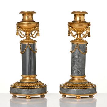 A pair of Louis XVI ormolu and Bleu turquin candlesticks.