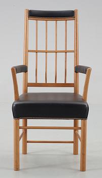 A Josef Frank cherrywood and black leather armchair by Svenskt Tenn, model 652.