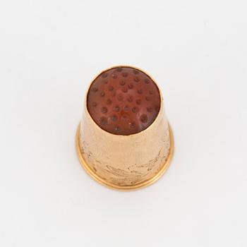 A thimble set with carnelian.