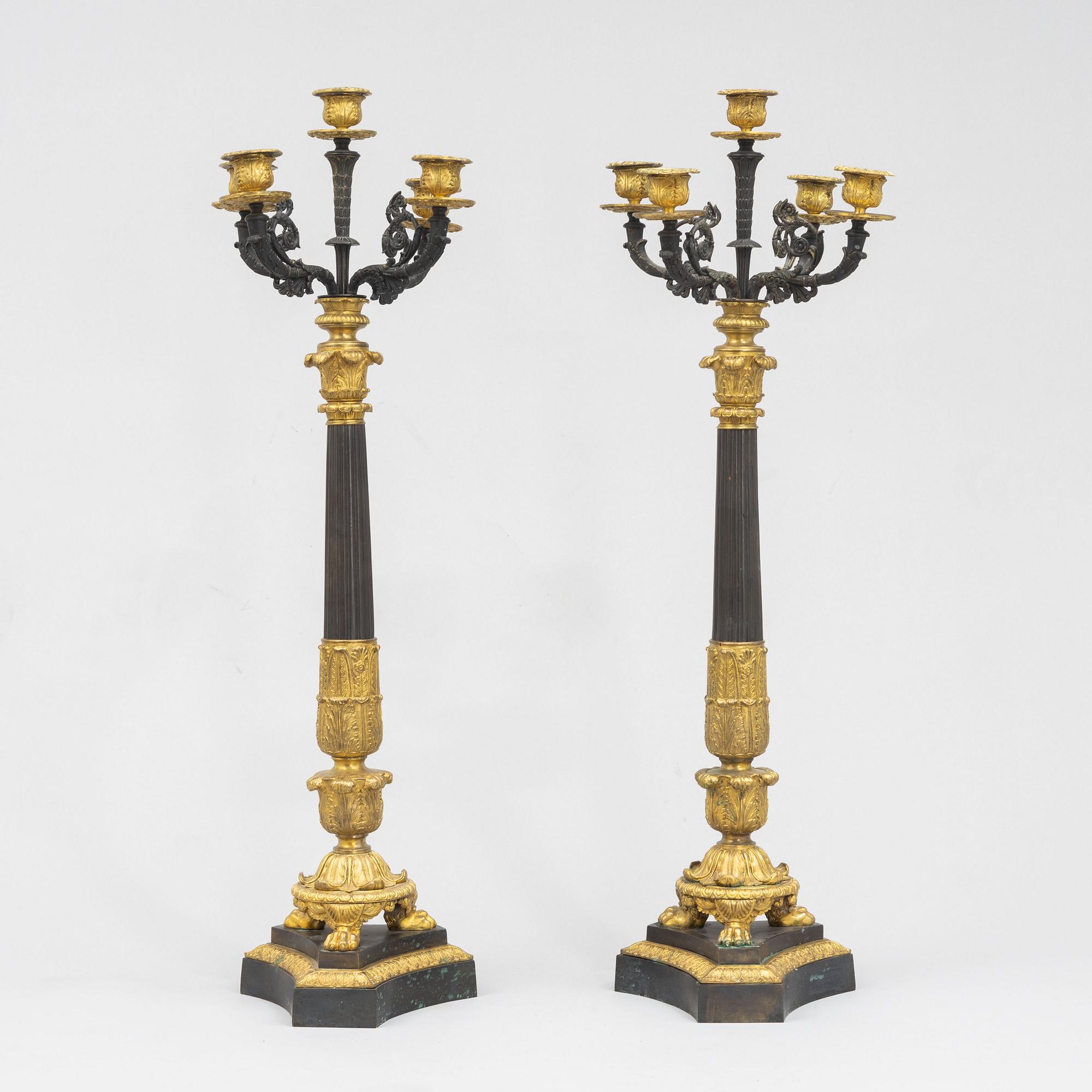 A pair of French Empire-style patinated and gilt bronze five-light candelabra, later part 19th century.