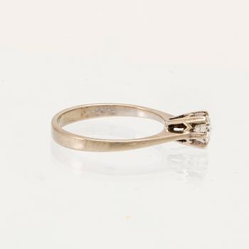 An 18K white gold solitaire ring set with a round brilliant-cut diamond.