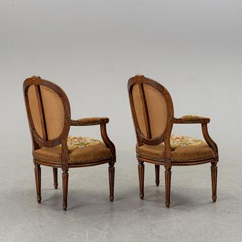 A pair of Louis XVI-style walnut armchairs circa 1900.