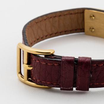 Hermès, a burgundy red leather bracelet with 14k gold plated watch, "Kelly Lock".
