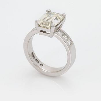 955. A RING set with an emerald-cut diamond.