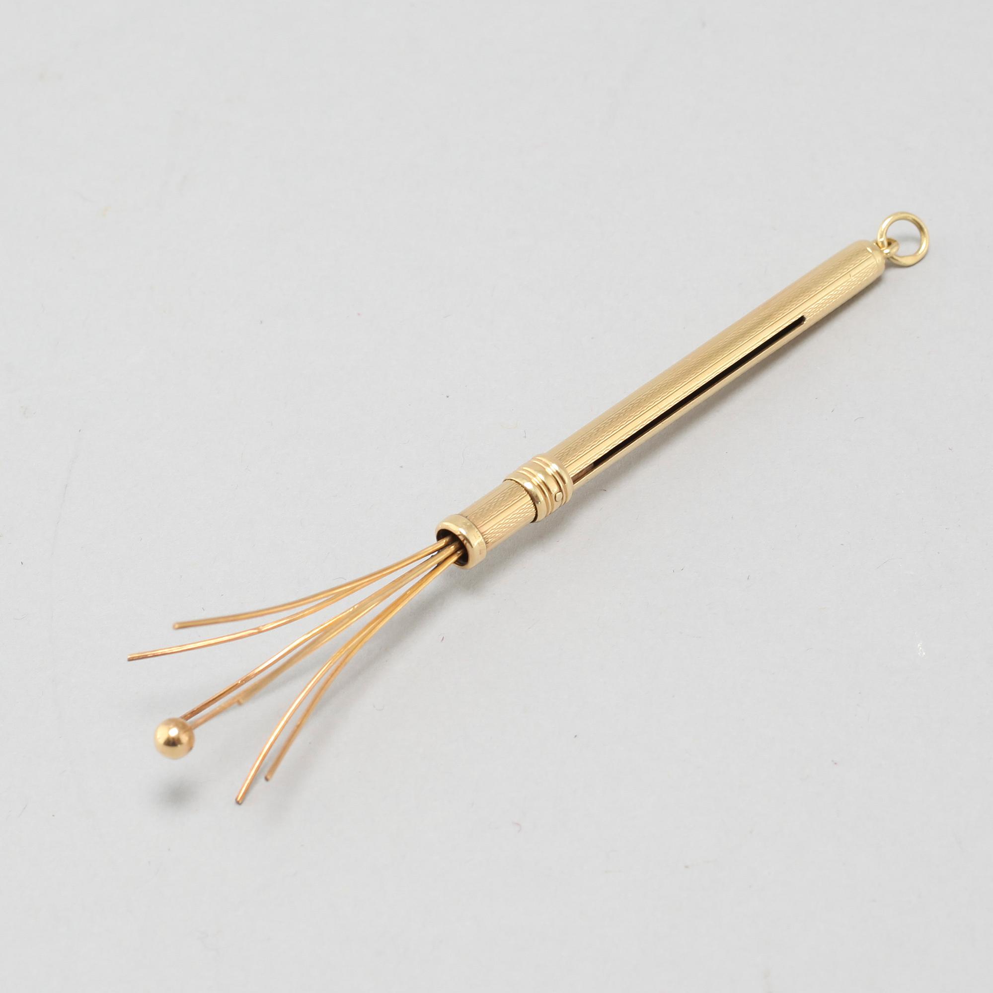 An 18k gold champagne whisk.