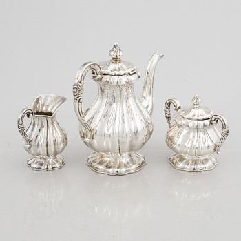 A silver coffee pot, a creamer and a sugarbowl, 20th Century.