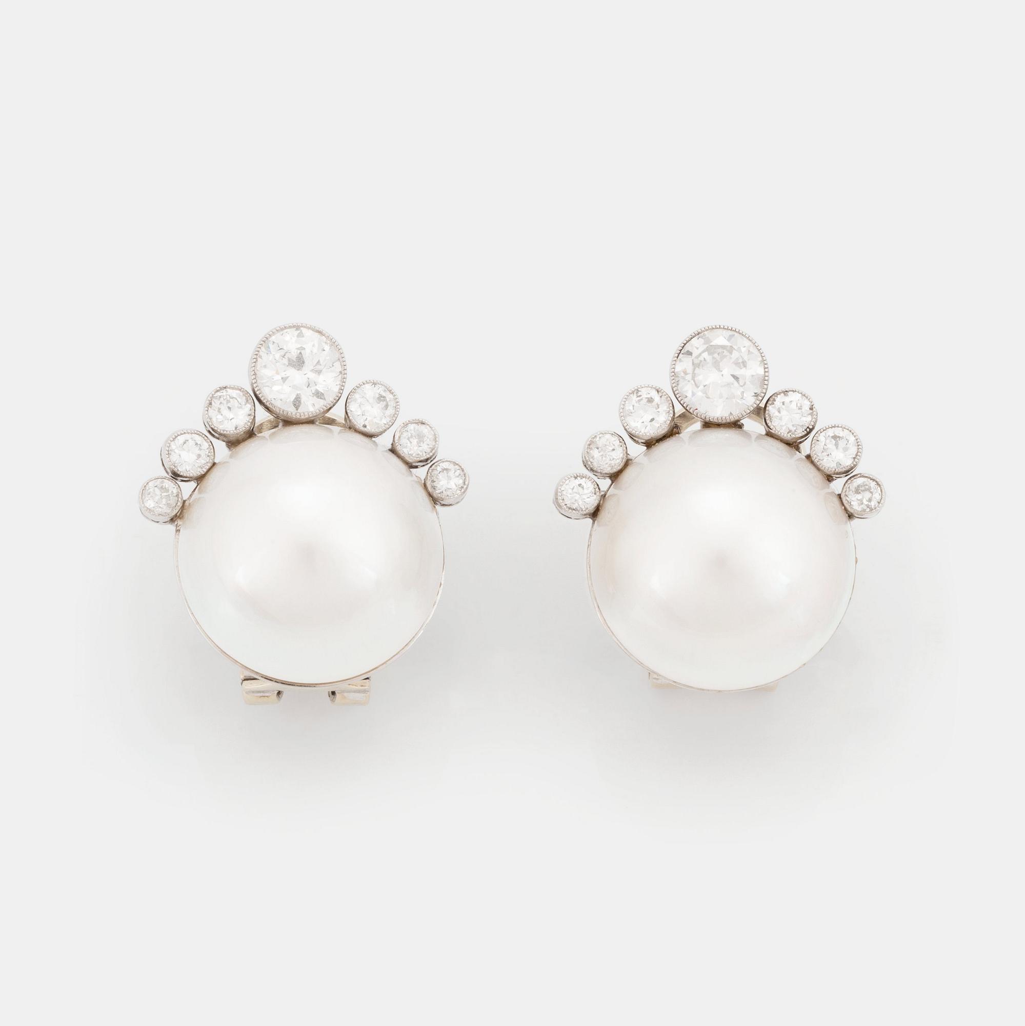 A pair of 18K white gold earrings set with mabe pearls and round brilliant-cut diamonds.